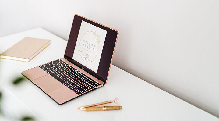 rose gold laptop on white desk
